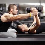 Personal trainer helping woman at gym